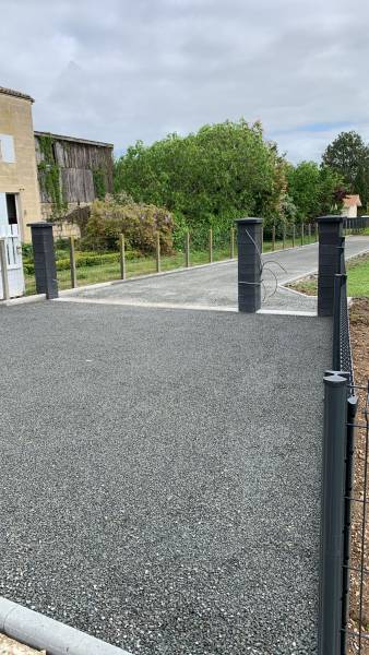 Entrée de portail en bicouche bitumeux gravillons gris sur le 33450